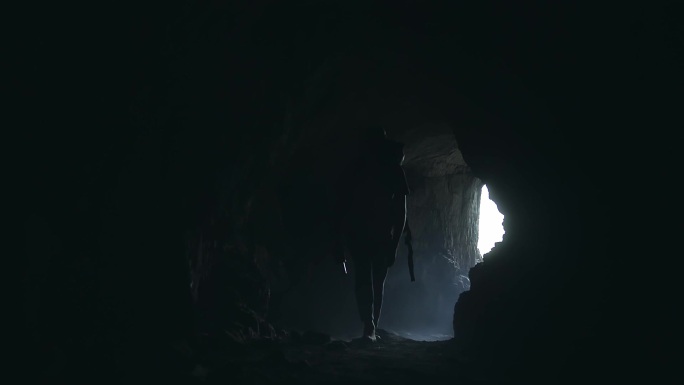 徒步探索洞穴的人黑洞岩洞走出来背包客探洞