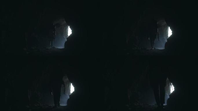 徒步探索洞穴的人黑洞岩洞走出来背包客探洞
