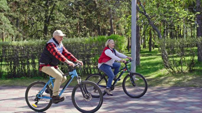 老人夫妇在公园里骑自行车