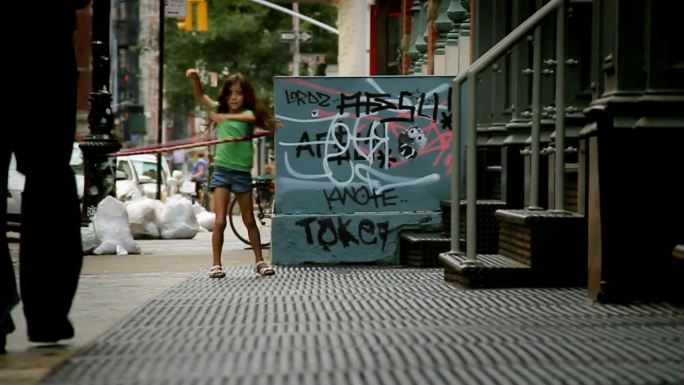 在纽约soho街上玩呼啦圈的小女孩
