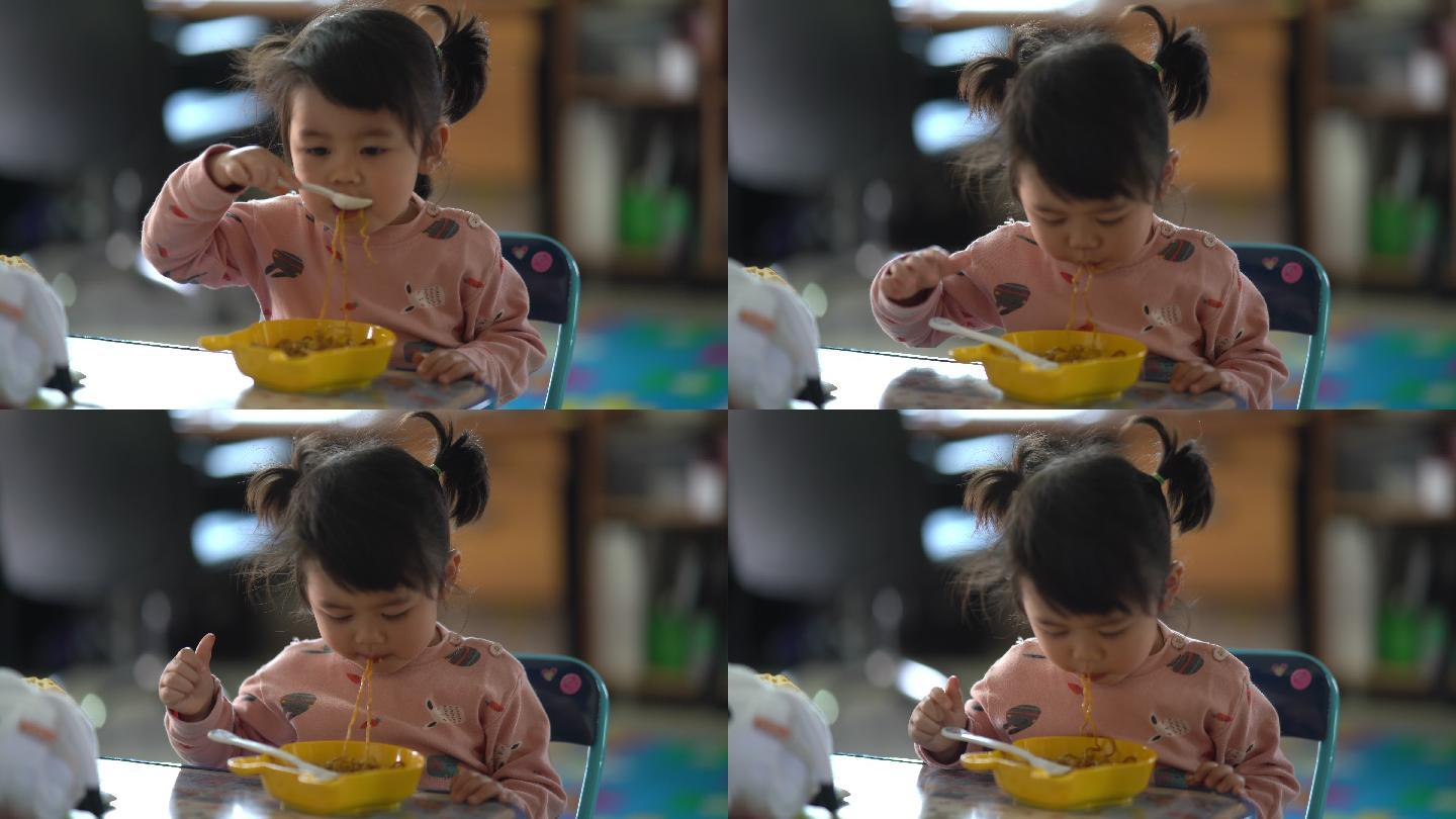 可爱的亚洲宝宝在桌上吃面条