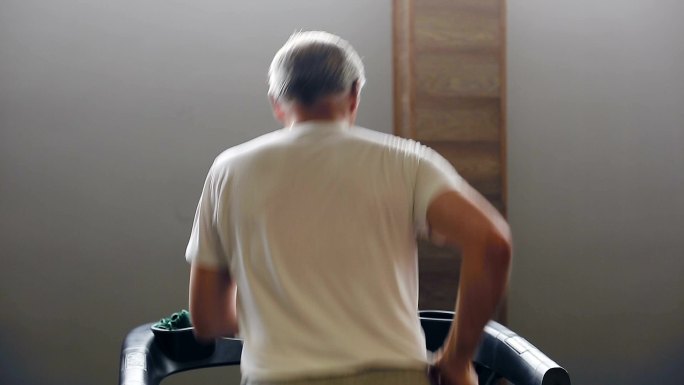 老年男子在健身房的跑步机上锻炼