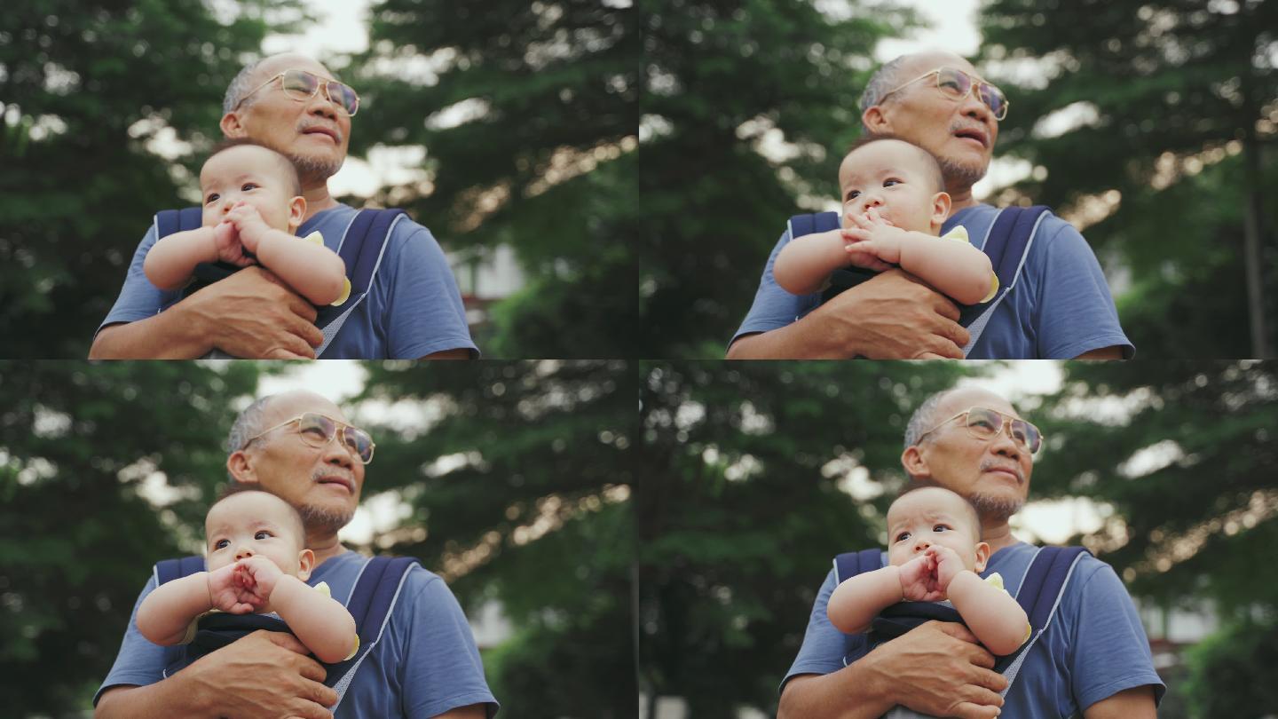 祖父微笑着抱着他可爱的小孙子