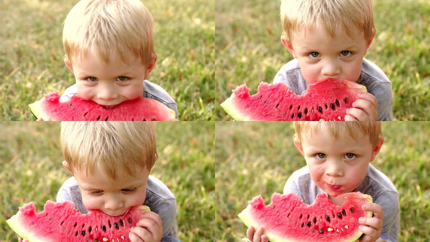 夏天，一个小男孩在公园里吃西瓜