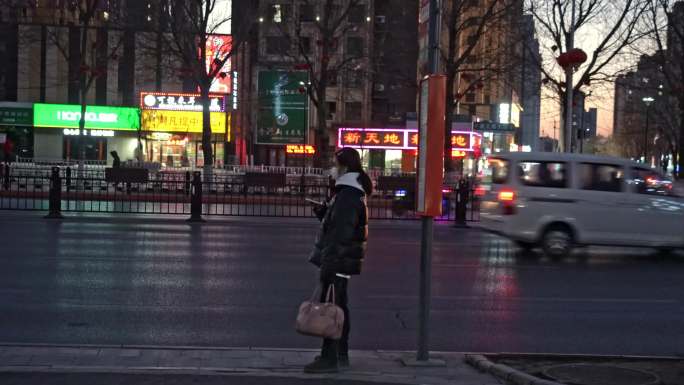 一个人女孩在寒风中独自等候公交车
