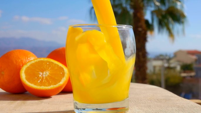 特写橙汁倒进玻璃杯