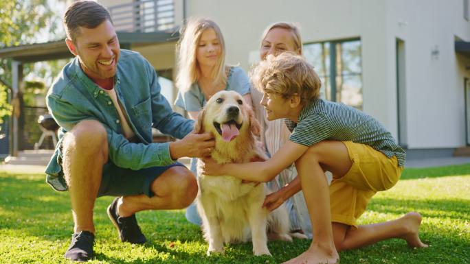 在草坪上，一家四口和金色猎犬合影。