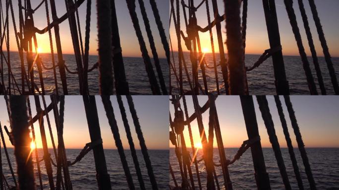 夕阳透过一艘旧帆船的护罩和索具。