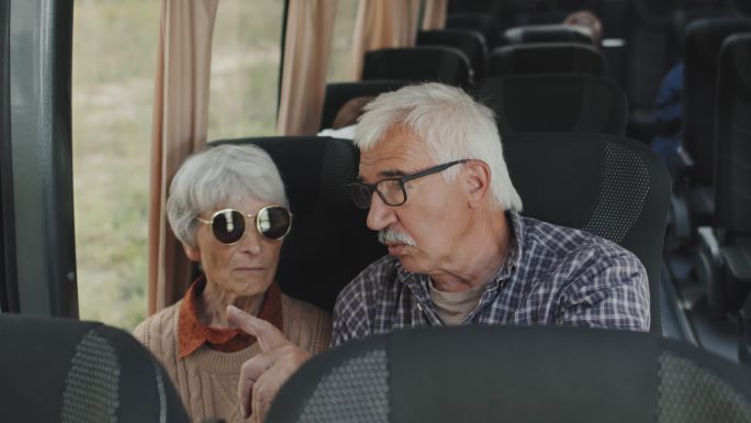 老年夫妇在公交车上聊天