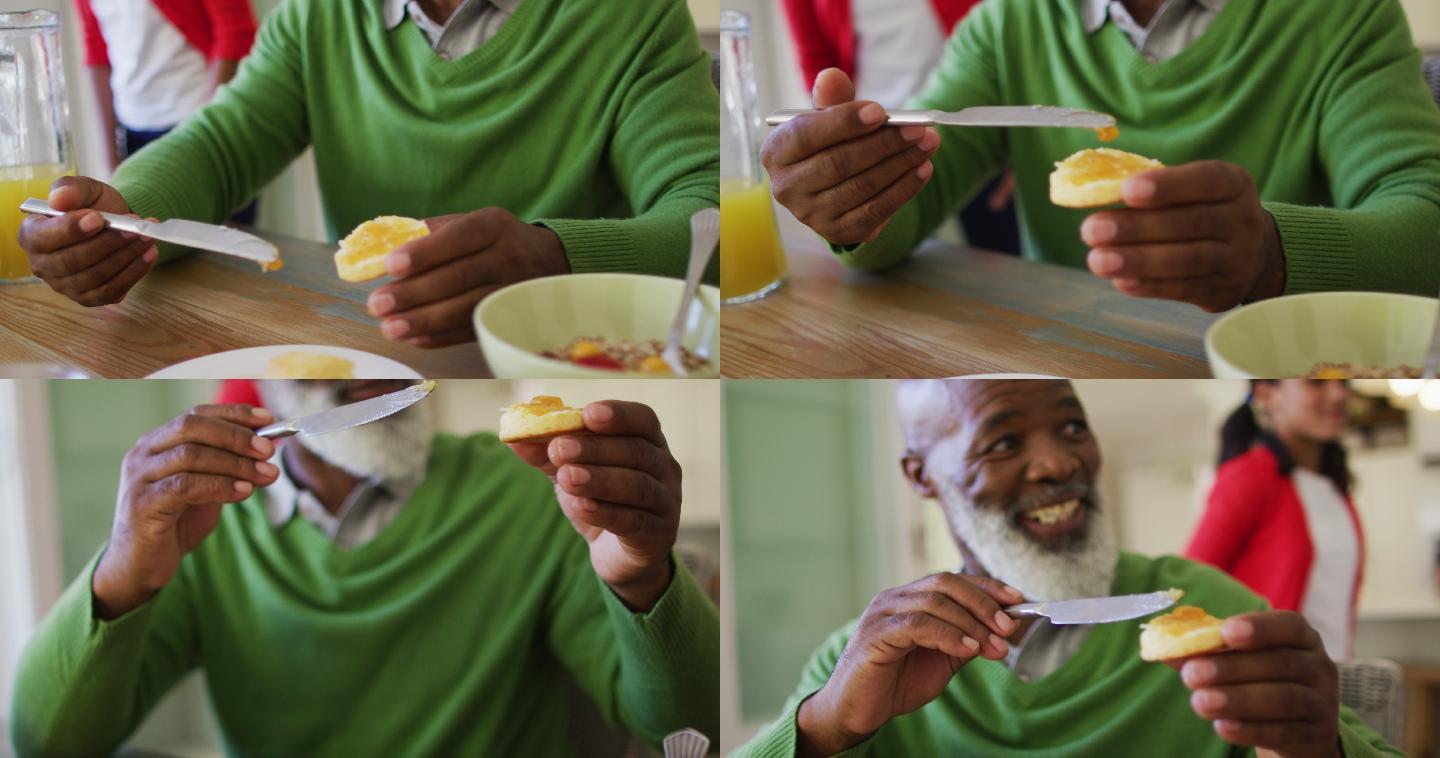 老人在家和家人一起吃早餐时涂果酱