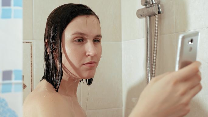 女孩在淋浴时洗澡使用手机