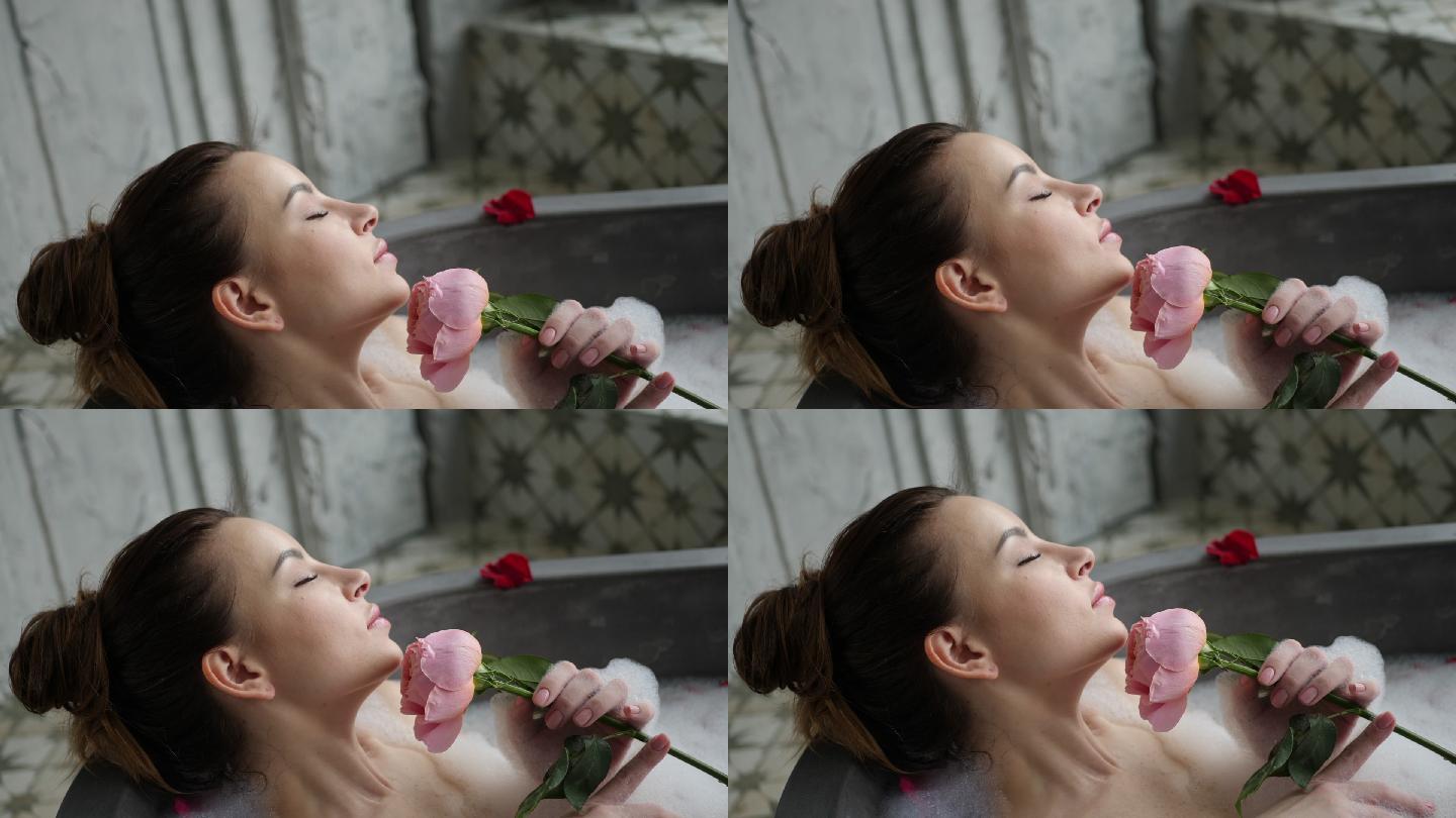 女孩躺在浴缸里，手里拿着一朵玫瑰花