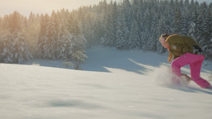 小女孩在雪地里追赶她的狗