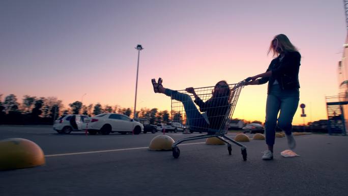 两位女子在超市停车场玩得很开心