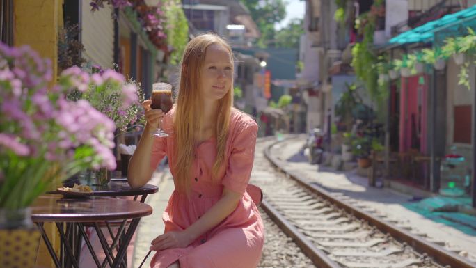 美女在铁路旁喝咖啡