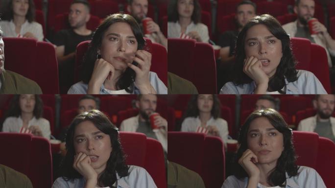 在电影院看电影时哭泣的女人
