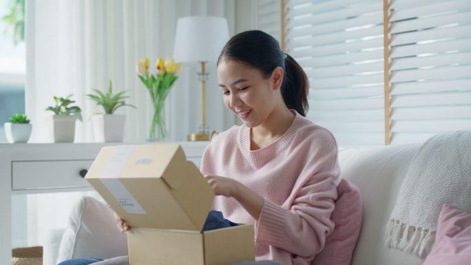 女人开心地在家里打开送货箱