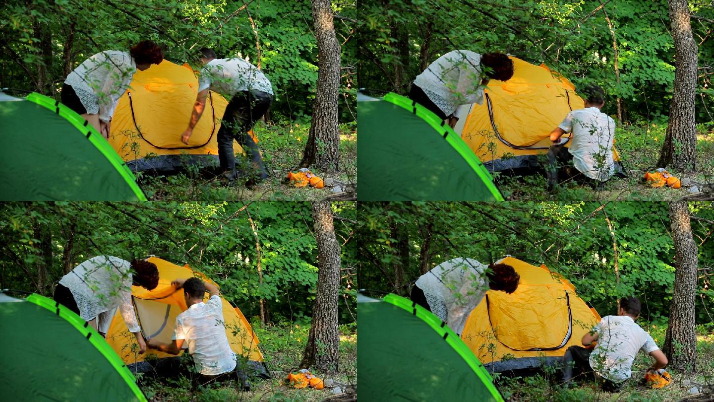 夫妻在落叶林中搭帐篷