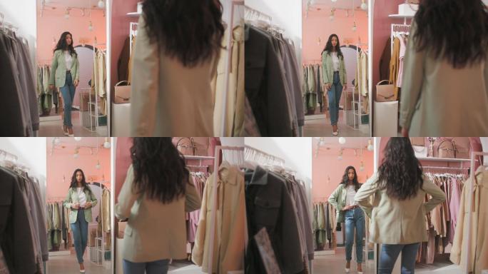 美女站在一家服装店的镜子前试衣