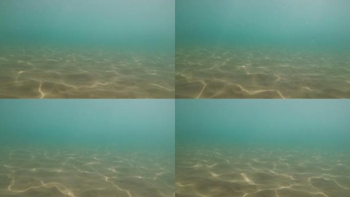 蓝色海水在沙质海底的阳光折射