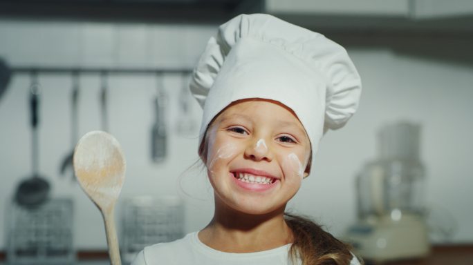 一个戴着厨师帽的漂亮小女孩