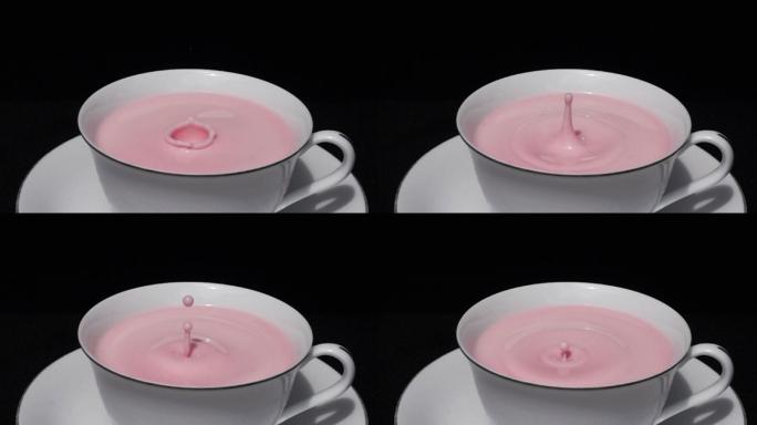 将草莓奶滴在白色杯子中的草莓奶表面