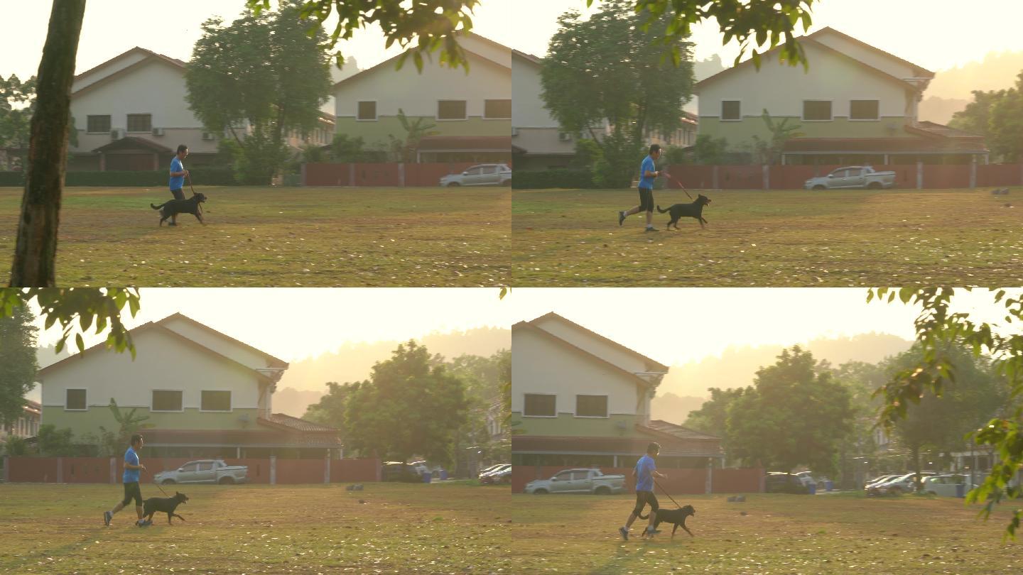 晨曦中奔跑者和狗在球场上的剪影