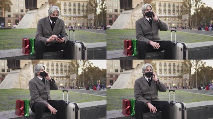 一个戴着口罩的男人在旅行中给家人打电话。