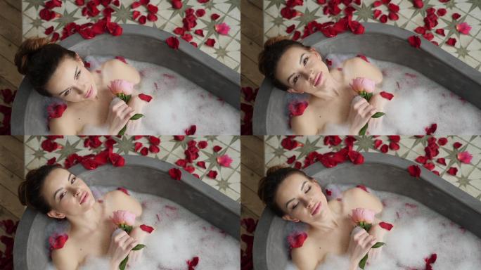 女孩躺在浴缸里，手里拿着一朵玫瑰花