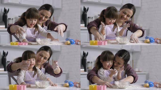 母亲和小女孩穿着围裙玩面粉
