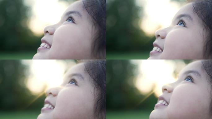 快乐的小女孩在大自然中仰望天空