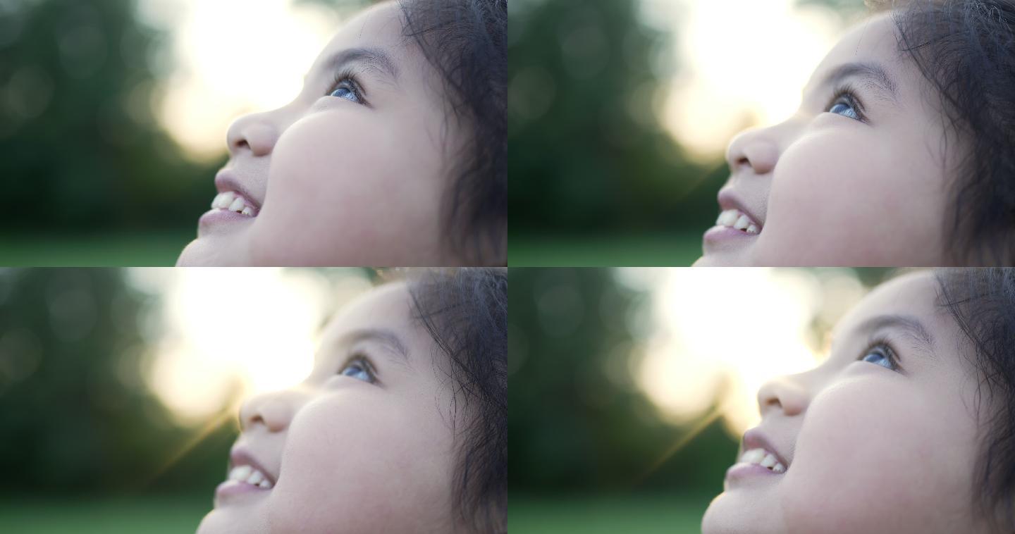 快乐的小女孩在大自然中仰望天空
