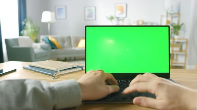 用一台带有绿色屏幕的笔记本电脑工作。