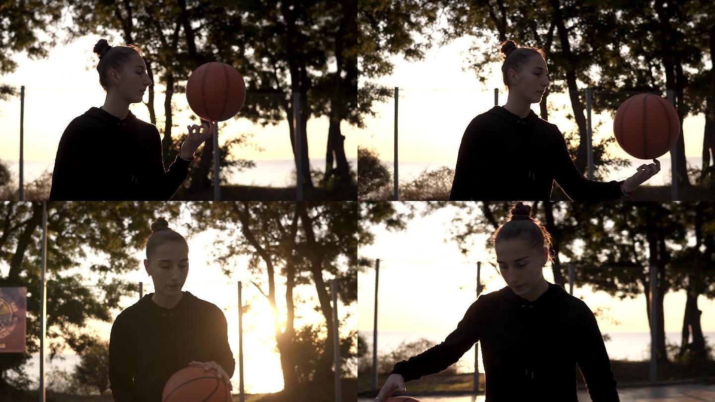 漂亮女孩在户外用手指旋转篮球