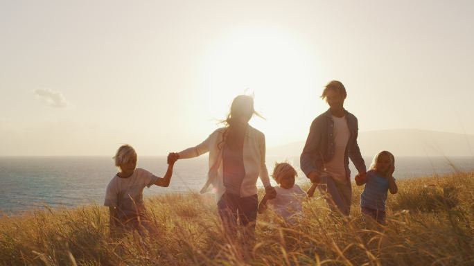日落时分一家人到海边金色的田野里散步