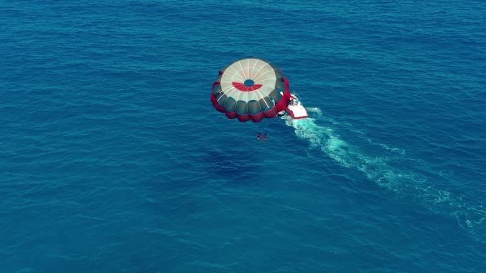 人们乘坐摩托艇拖曳降落伞飞行
