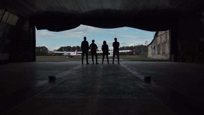 四个人站在飞机库里