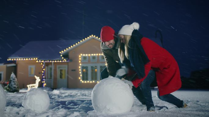 幸福的年轻夫妇堆雪人