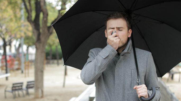 雨下使用哮喘吸入器的哮喘患者