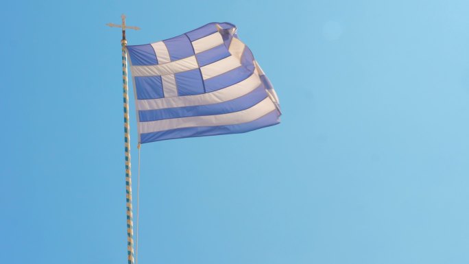 希腊国旗在晴朗的蓝天下飘扬