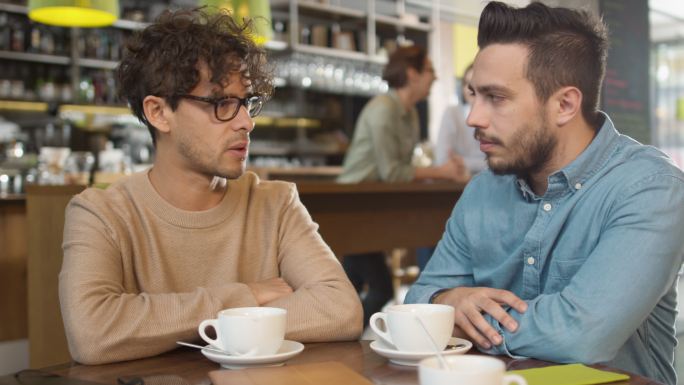 两个年轻人在舒适的咖啡馆聊天