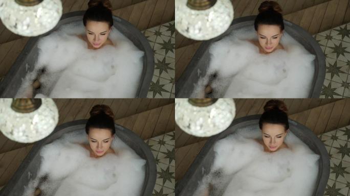 女孩躺在一个巨大的泡沫石浴缸里