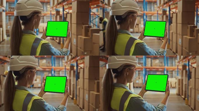 戴着安全帽的女员工在仓库中使用平板电脑
