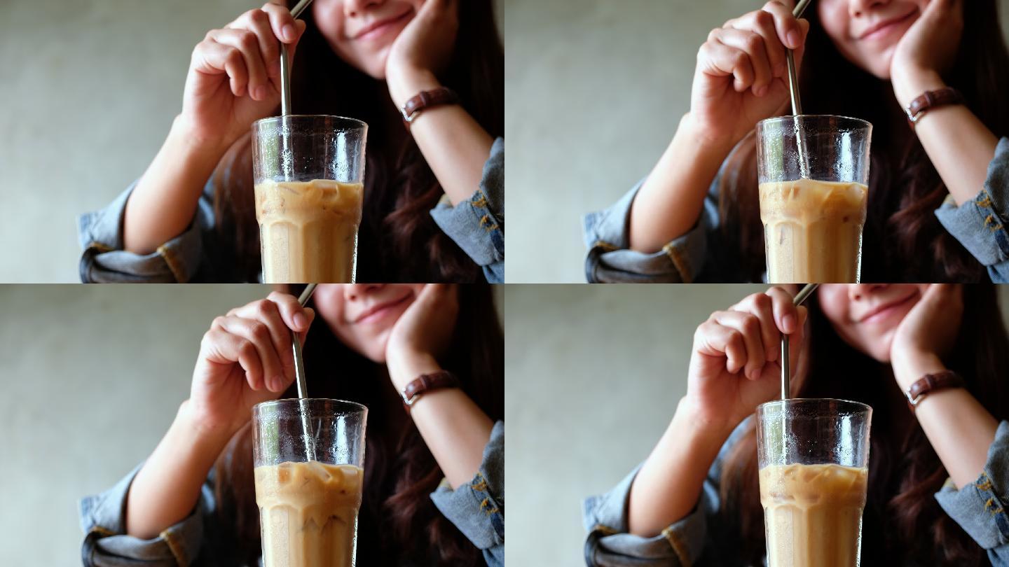 一个女人用不锈钢吸管搅拌冰咖啡