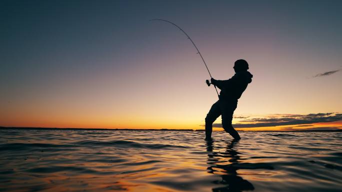 渔夫正在拉起鱼竿剪影海钓兴趣热爱大海海水