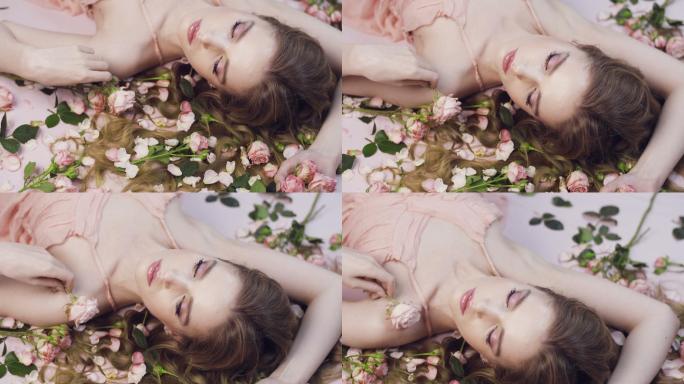 美丽的女孩躺在玫瑰里