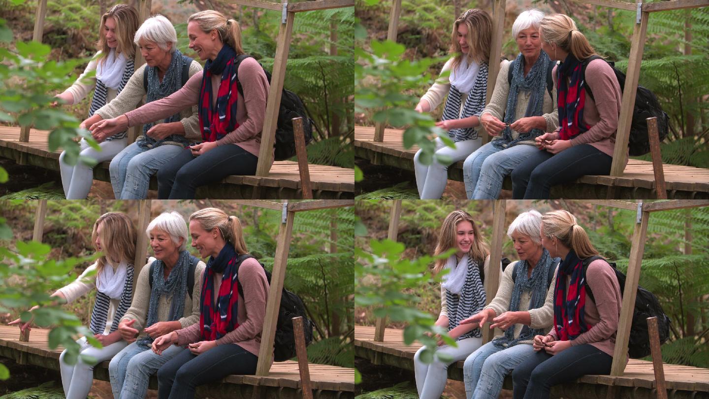 三代女人坐在森林里的一座桥上
