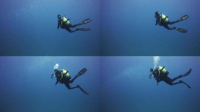 潜水员沉浸在礁石附近欣赏海底的美景