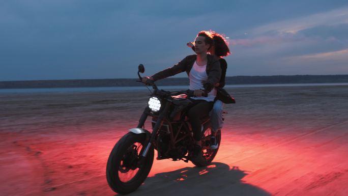 日落后，一对年轻夫妇骑着老式摩托车