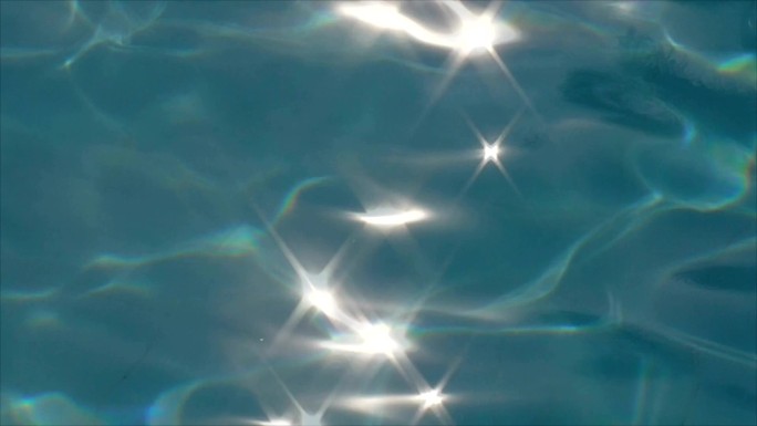 池水表面的强光。水面波光水波星光效果清澈